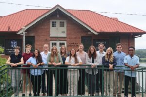 Line of student interns standing in front of the Biology Field Station main building on the Ohio River.