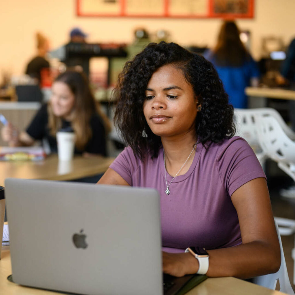 Student working on a laptop at Java City.