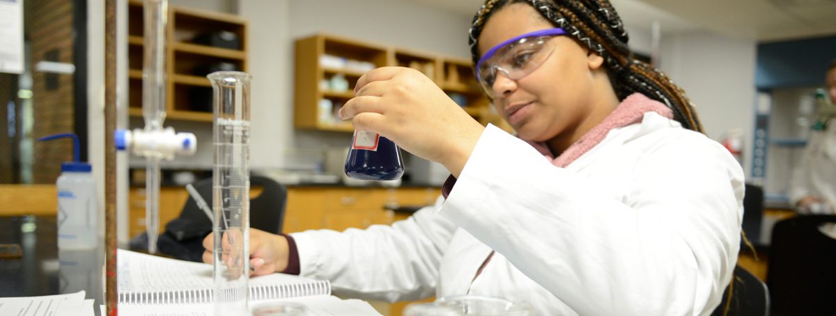 student examining a beaker